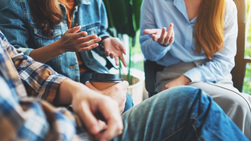 Close up of hands of 3 people sitting in an group session