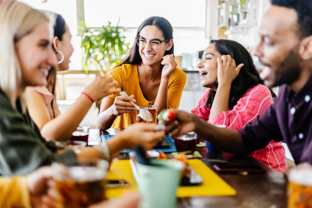 Group of people having fun while meeting sitting in a table together