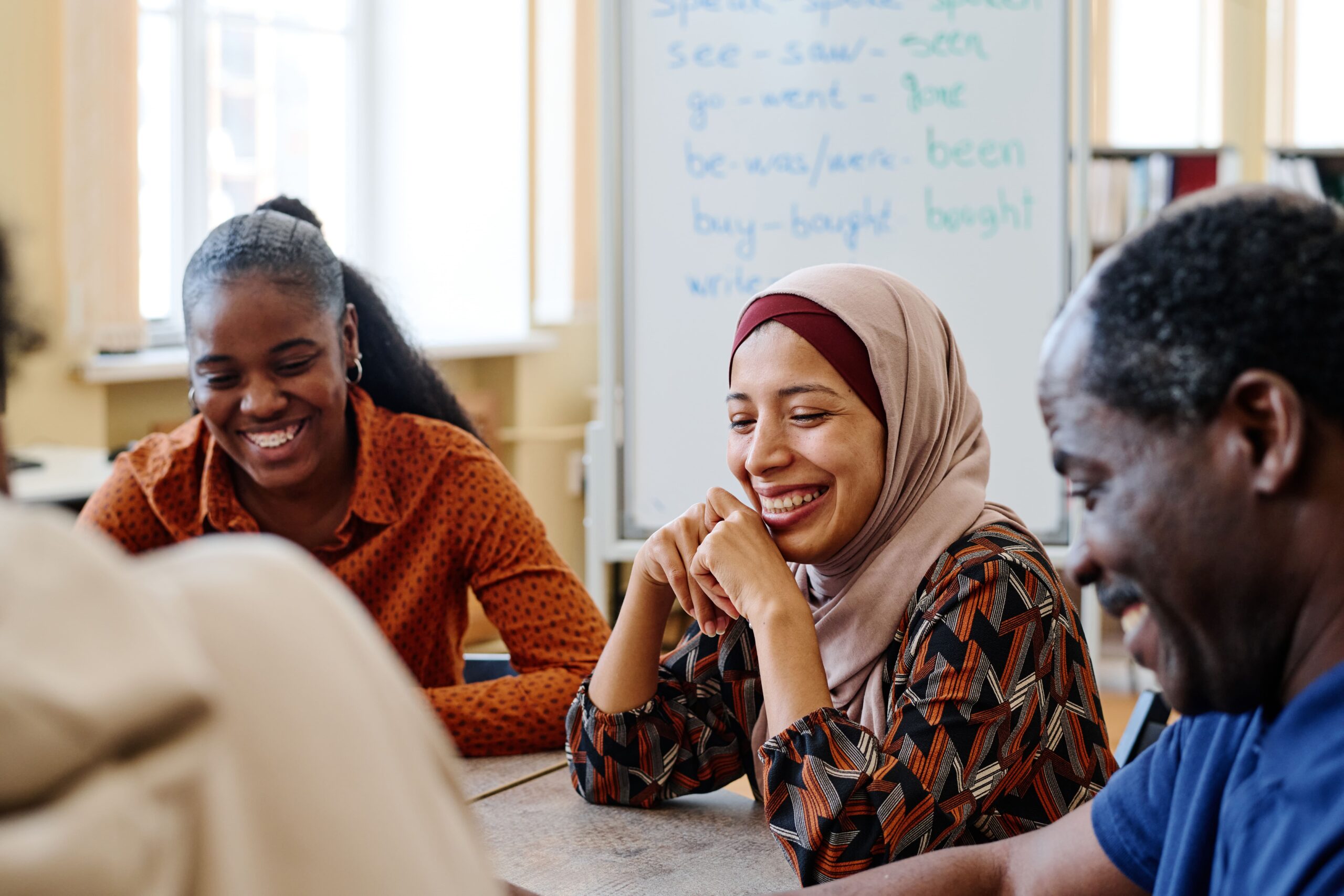 Multicultural people smiling while sitting in a meeting like room